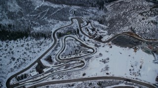 AX127_036E - 5.5K aerial stock footage approach and tilt to tracks at Utah Olympic Park with winter snow at sunset, Utah