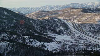 5.5K aerial stock footage approach I-80 and homes on snowy mountain slopes at sunset in winter, Park City, Utah Aerial Stock Footage | AX127_041E