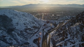 5.5K aerial stock footage approach Salt Lake City suburbs from I-80 through Wasatch Range at sunset, Utah Aerial Stock Footage | AX127_070E