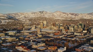 5.5K aerial stock footage of wide orbit of Downtown Salt Lake City with winter snow at sunset, Utah Aerial Stock Footage | AX127_113E