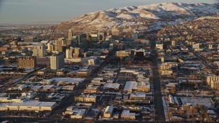 AX127_129E - 5.5K aerial stock footage of reverse view of Utah State Capitol, Downtown Salt Lake in winter at sunset