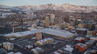 5.5K aerial stock footage of Salt Palace and Downtown Salt Lake City buildings with winter snow at sunset, Utah Aerial Stock Footage | AX127_160