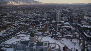 5.5K aerial stock footage orbit Utah State Capitol building to reveal Downtown Salt Lake City at sunset with winter snow Aerial Stock Footage | AX127_163E