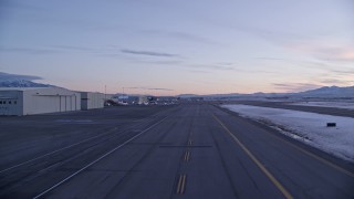 5.5K aerial stock footage of ascending near hangars and parked planes at SLC Airport in winter at sunset, Utah Aerial Stock Footage | AX128_004