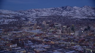 5.5K aerial stock footage of a wide view of Downtown SLC near snowy mountains at twilight, Utah Aerial Stock Footage | AX128_040E