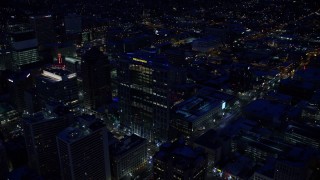 AX128_089E - 5.5K aerial stock footage orbit Wells Fargo Building to reveal Gallivan Center with winter snow at night, Downtown Salt Lake City, Utah