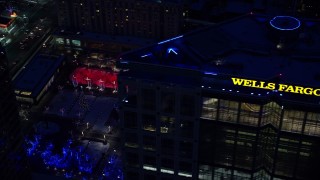 AX128_095E - 5.5K aerial stock footage orbit office buildings and Gallivan Center, lit for Christmas in winter at night. Downtown SLC, Utah