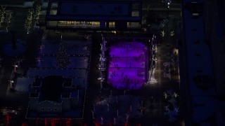 5.5K aerial stock footage orbit ice rink and Christmas tree at Gallivan Center with winter snow at night, Downtown Salt Lake City, Utah Aerial Stock Footage | AX128_097