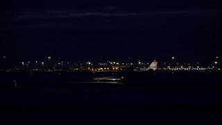 5.5K aerial stock footage track private jet on airport runway at night in winter, Salt Lake City International Airport, Utah Aerial Stock Footage | AX128_118E