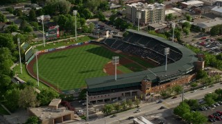 AX129_024 - 5.5K aerial stock footage of orbiting Spring Mobile Ballpark during baseball game, Salt Lake City, Utah