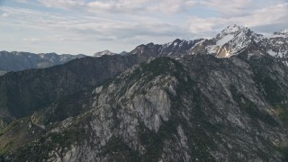 5.5K aerial stock footage of flying by mountain peak with light snow, Wasatch Range, Utah Aerial Stock Footage | AX129_129E