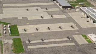 AX130_024E - 5.5K aerial stock footage of flying away from helicopters and hangars at South Valley Regional Airport, Utah