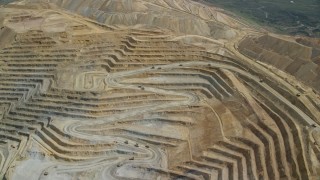 5.5K aerial stock footage of flying away from gravel haulers, Bingham Canyon Mine, Utah Aerial Stock Footage | AX130_055E