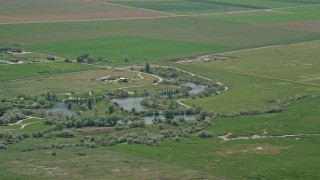 AX130_111E - 5.5K aerial stock footage of a barn and Burraston Ponds, Mona, Utah