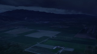 4K day for night color corrected aerial footage of approaching small rural town, fly over farm fields, Nephi, Utah Aerial Stock Footage | AX130_116_DFN