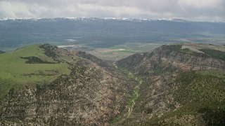 5.5K aerial stock footage of approaching a valley over mountain peaks, Wasatch Range, Utah Aerial Stock Footage | AX130_133E