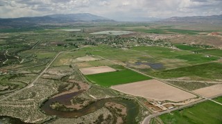 AX130_160E - 5.5K aerial stock footage of approaching a rural town, farms, and Redmond Lake, Redmond, Utah