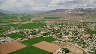 5.5K aerial stock footage of flying by small rural town, surrounded by farmland, Aurora, Utah Aerial Stock Footage | AX130_169E