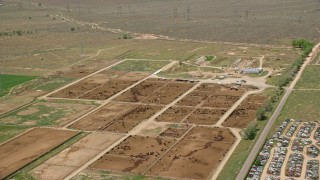 AX130_174E - 5.5K aerial stock footage of flying by large cattle ranch, surrounded by fields, Aurora, Utah