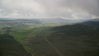 AX130_211E - 5.5K aerial stock footage of a tiny farming town in a green valley, Burrville, Utah