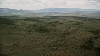 5.5K aerial stock footage of a wide view of green hills, trees, approaching country road, Fishlake National Forest, Utah Aerial Stock Footage | AX130_226E