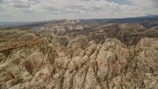 AX130_288E - 5.5K aerial stock footage of passing by the Waterpocket Fold rock formations, seen from a mesa, Capitol Reef National Park, Utah