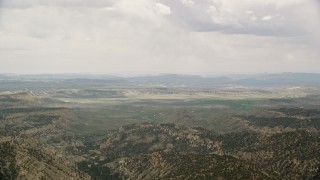 5.5K aerial stock footage of flying by green valley beyond mountain ridges, Grand Staircase-Escalante National Monument, Utah Aerial Stock Footage | AX130_419