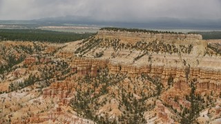 5.5K aerial stock footage of passing by groups of hoodoos around base of mesa, Bryce Canyon National Park, Utah Aerial Stock Footage | AX130_430E