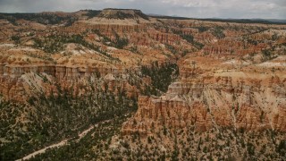 AX130_450 - 5.5K aerial stock footage of a view of hoodoos, buttes, canyon, mesa in the background, Bryce Canyon National Park, Utah