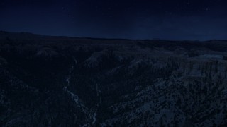 AX130_454_DFN - Aerial stock footage of 4K day for night color corrected aerial footage flyby wide canyon with trees, surrounded by hoodoos, buttes, Bryce Canyon National Park, Utah