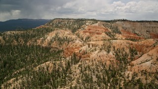 5.5K aerial stock footage of groups of hoodoos near a large mesa, Bryce Canyon National Park, Utah Aerial Stock Footage | AX130_456E