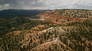 AX130_458E - 5.5K aerial stock footage pan across hoodoos, steep mesa slope, revealing more mesas, Bryce Canyon National Park, Utah