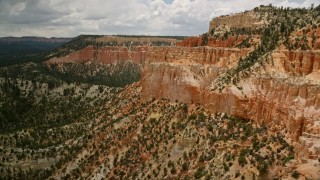 5.5K aerial stock footage of flying by hoodoos on a steep mesa cliff and across a canyon, Bryce Canyon National Park, Utah Aerial Stock Footage | AX130_461E