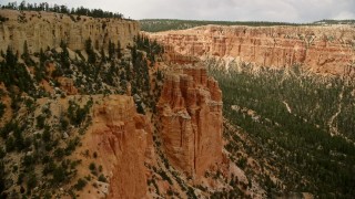 AX130_466E - 5.5K aerial stock footage of passing by hoodoos overlooking box canyon between mesas, Bryce Canyon National Park, Utah