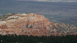 5.5K aerial stock footage of flying by cliffside hoodoos, buttes, distant valley, Bryce Canyon National Park, Utah Aerial Stock Footage | AX131_007