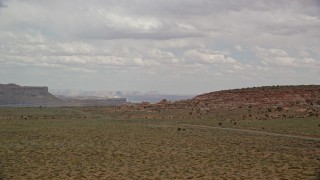 5.5K aerial stock footage of flying over butte, revealing small town and open desert, Big Water, Utah Aerial Stock Footage | AX131_112E