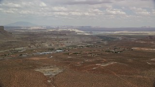 5.5K aerial stock footage of a tiny desert town, mesa in the distance, Big Water, Utah Aerial Stock Footage | AX131_118E