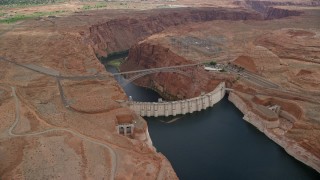 AX131_135E - 5.5K aerial stock footage of orbiting the Glen Canyon Dam and Bridge, Arizona