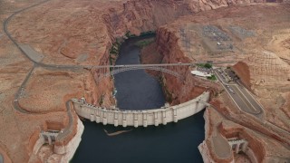 AX131_142E - 5.5K aerial stock footage orbit above the Glen Canyon Dam and Bridge, Arizona