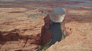 AX131_145E - 5.5K aerial stock footage of following Colorado River to approach the Glen Canyon Dam and Bridge, Arizona