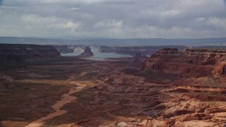 5.5K aerial stock footage of flying by buttes, Lake Powell in the distance, Navajo Nation Reservation, Arizona Aerial Stock Footage | AX132_008