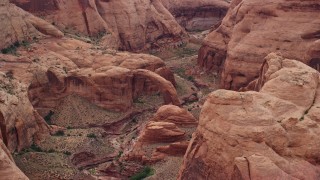 AX132_049 - 5.5K aerial stock footage pass by a natural stone bridge at Rainbow Bridge National Monument, Utah