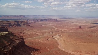 5.5K aerial stock footage of of buttes and a wide desert valley, Navajo Nation Reservation, Arizona, Utah Aerial Stock Footage | AX132_095E