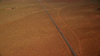 AX132_128E - 5.5K aerial stock footage tilt up Oljeto Road, revealing Oljeto Mesa, Navajo Nation Reservation, Arizona, Utah