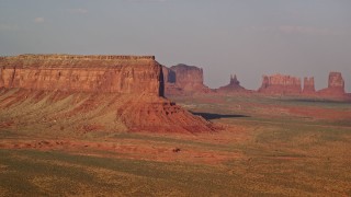 5.5K aerial stock footage of passing by Eagle Mesa, distant buttes, Monument Valley, Utah, Arizona, sunset Aerial Stock Footage | AX133_002E