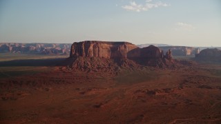 AX133_030E - 5.5K aerial stock footage of Spearhead Mesa in desert valley, Monument Valley, Utah, Arizona, twilight