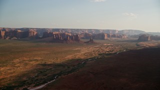 AX133_034E - 5.5K aerial stock footage of approaching buttes, mesas across desert, Monument Valley, Utah, Arizona, twilight