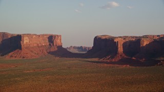 5.5K aerial stock footage of mesas across desert valley, Monument Valley, Utah, Arizona, twilight Aerial Stock Footage | AX133_036