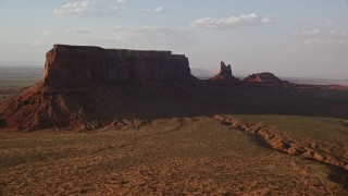 5.5K aerial stock footage of flying by Eagle Mesa and Setting Hen Butte, Monument Valley, Utah, Arizona, twilight Aerial Stock Footage | AX133_088