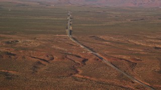 5.5K aerial stock footage of Highway 163 through desert valley, Monument Valley, Utah, Arizona, twilight Aerial Stock Footage | AX133_097E